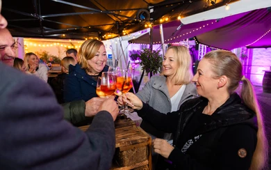 Freunde stoßen an in der Weinbar auf der Herbstwoche
