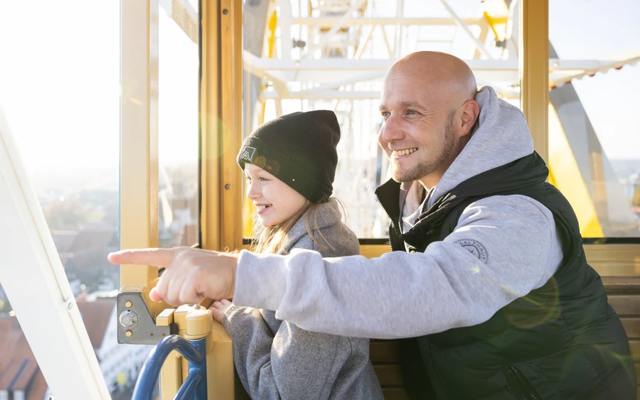 Vater und Tochter fahren Riesenrad